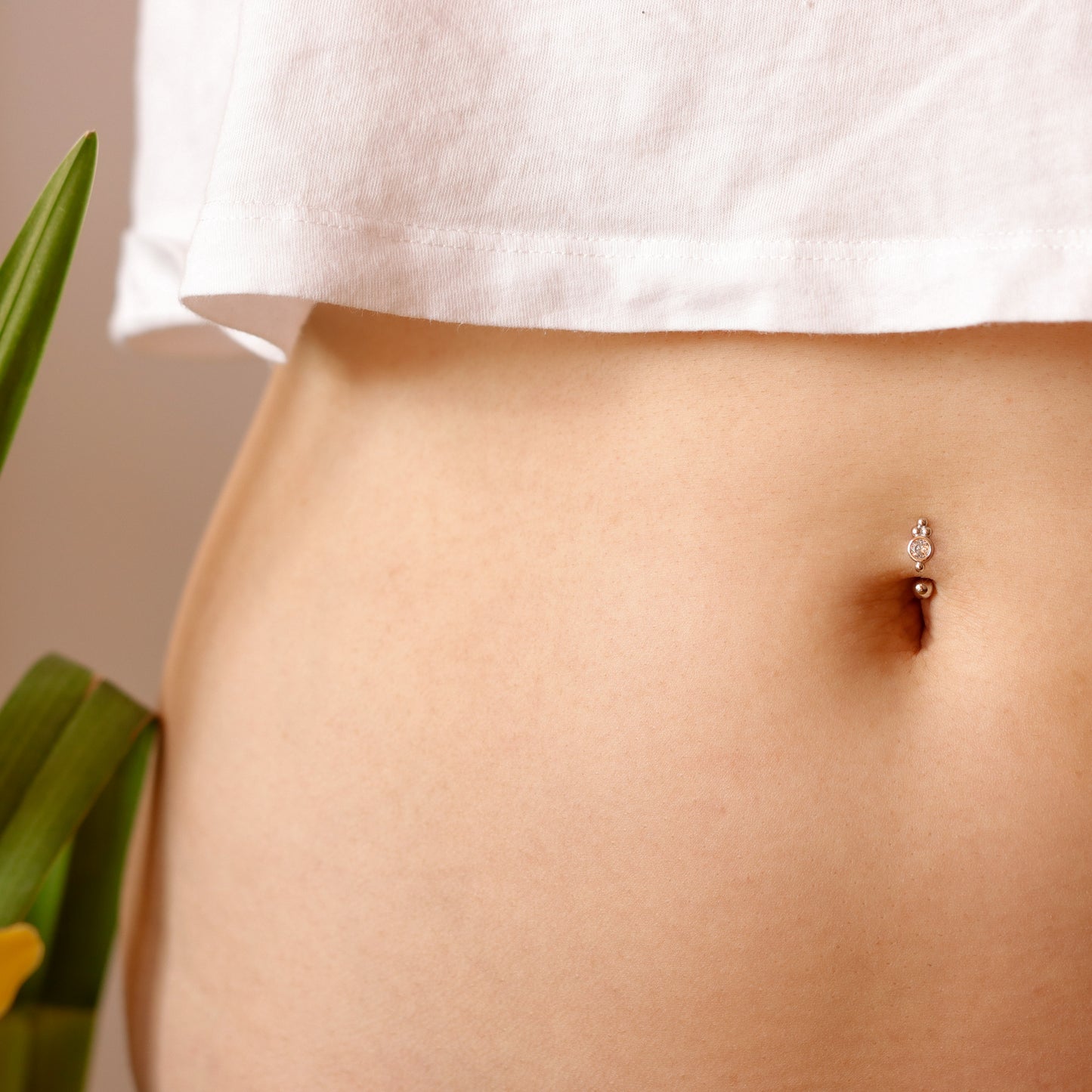 Model wearing a dainty sterling silver belly ring for a chic, minimalist look.