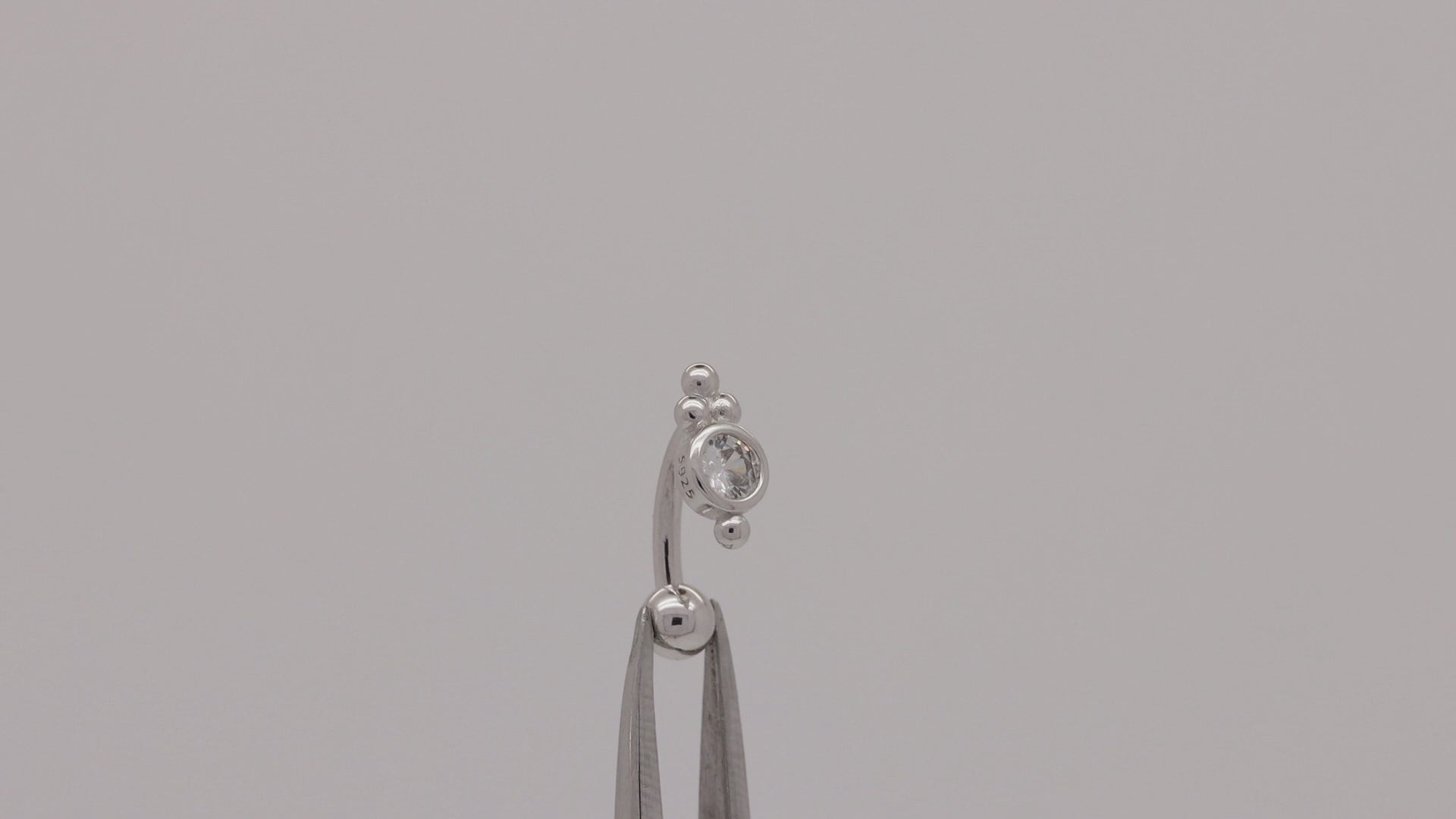 Video of a dainty sterling silver belly ring with a trinity ball design and screw-on bead.