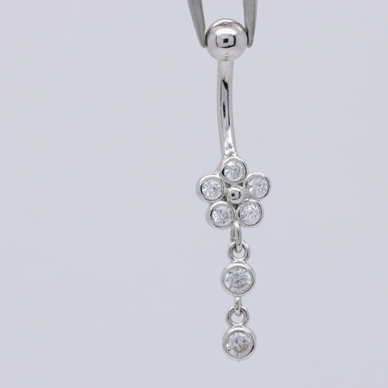Video demonstration of sterling silver flower dangle belly ring with cubic zirconia charm, showing how it shines and moves