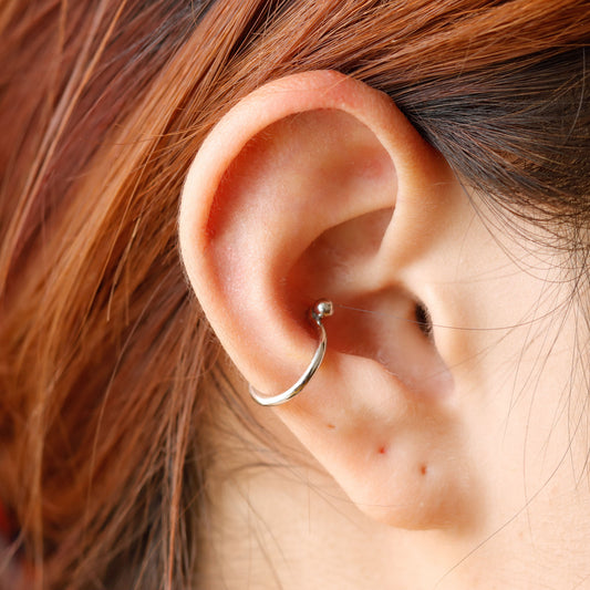 Close-up of an ear with a silver hoop earring